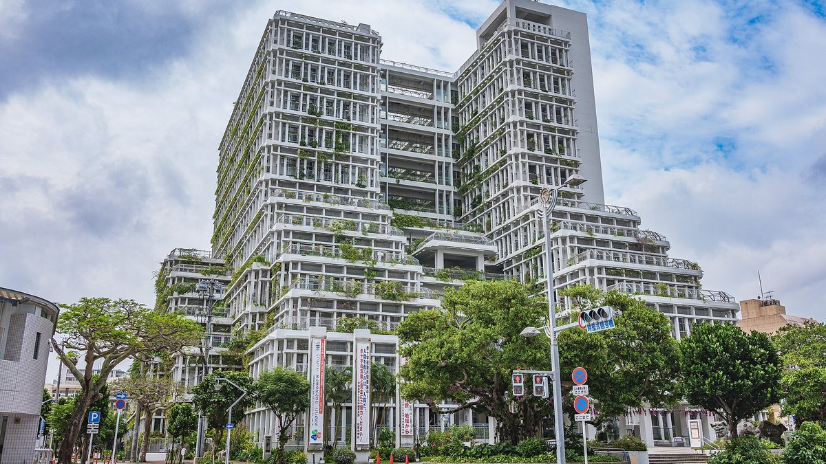 那覇市役所の本庁舎。白い格子状の外壁に植物が茂る高層の建物