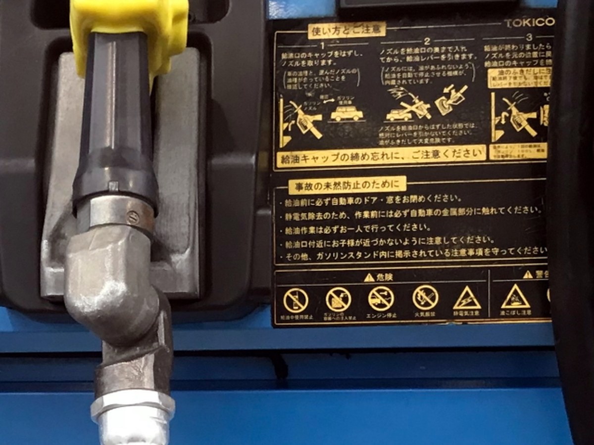 セルフ式ガソリンスタンドの計量機の注意書き。給油作業は必ずお一人で、給油口付近にお子様が近づかないように、と書かれている