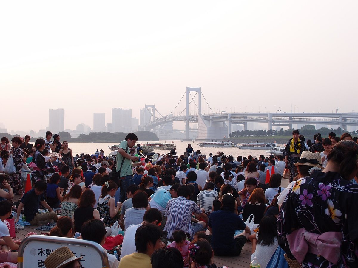 2013年の東京湾大華火祭の開始前、お台場海浜公園の砂浜に敷物を広げて場所取りをする大勢の観客