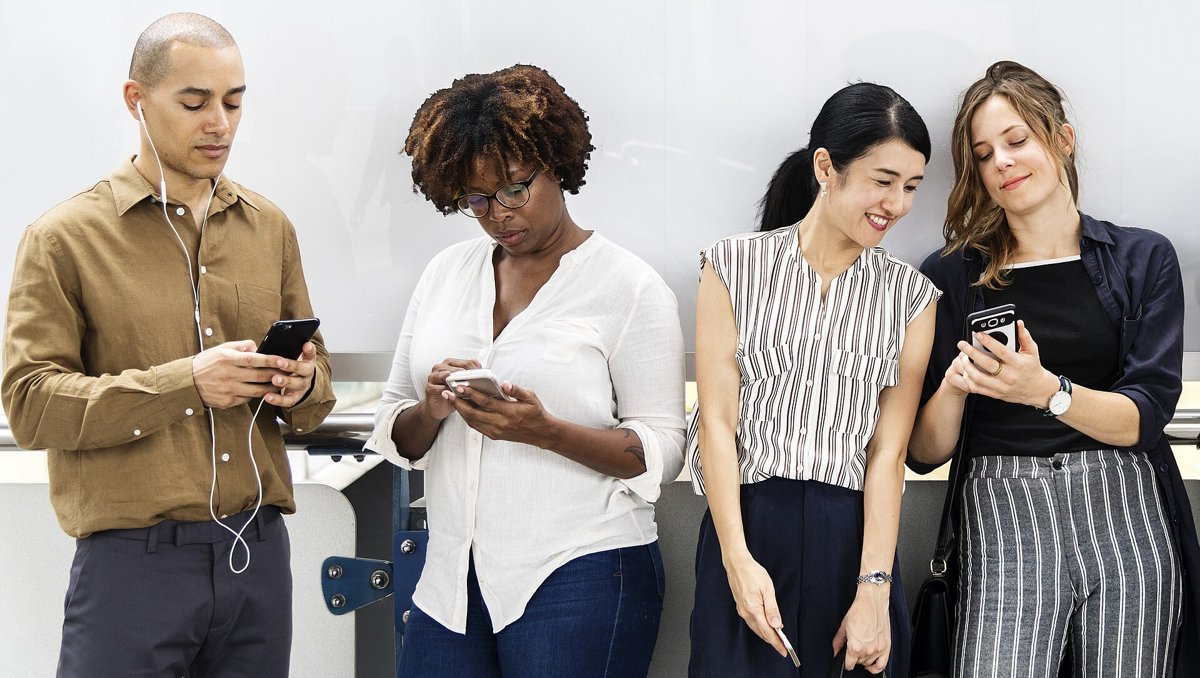 並んでスマートフォンを見る若い人たち
